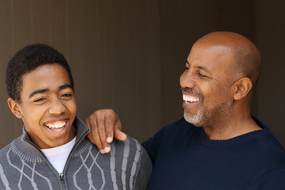 Two men laughing, a father and son helping with the addiction recovery healing process.