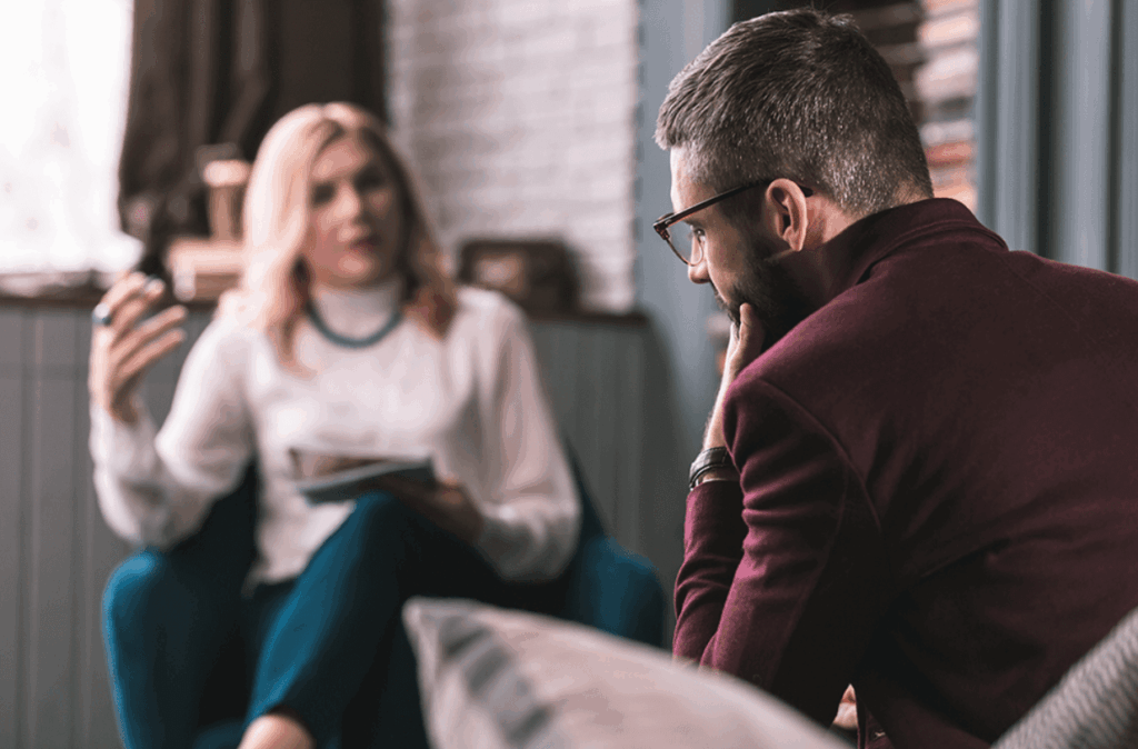 Man sitting down talking in therapy about calming the mind and using dialectic behavior therapy.