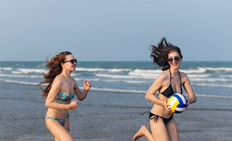 Two women running on the beach, summer time events and sobriety.