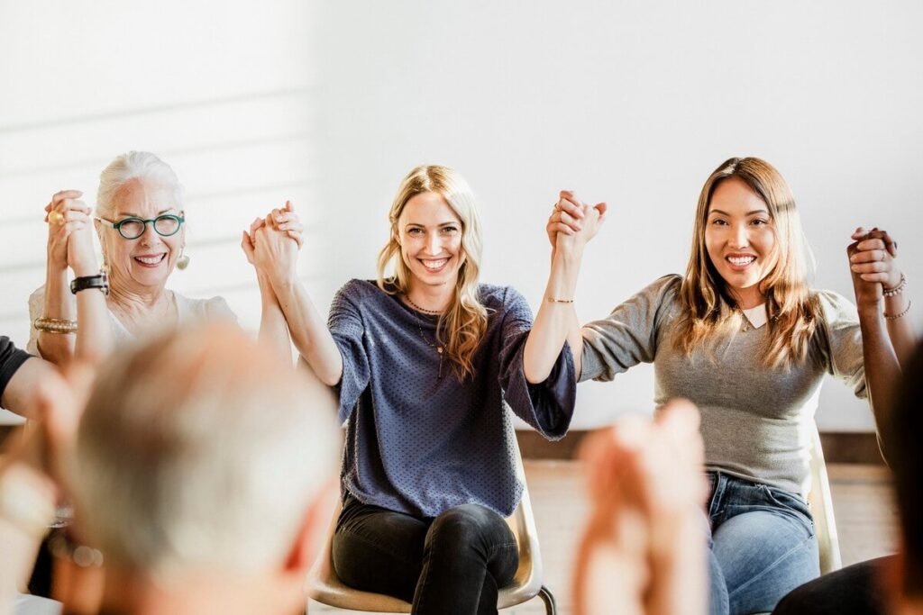 Group of diverse people holding hands up in the air